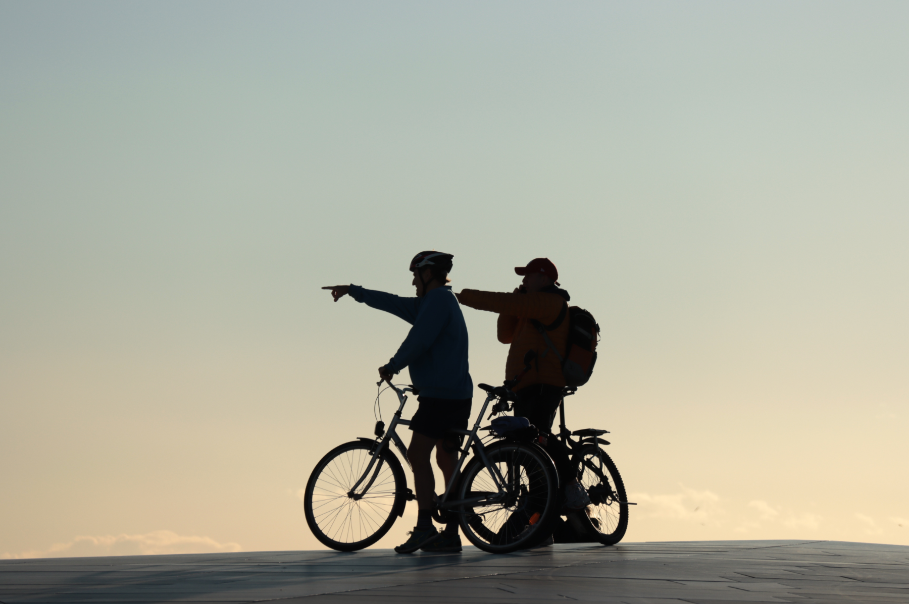 Cyclists pointing out sights at sunset.